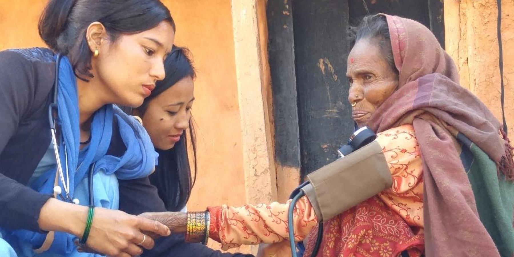 Community health workers check the blood pressure of a woman with breathing difficulties, Achham district, Nepal, Feb 2018