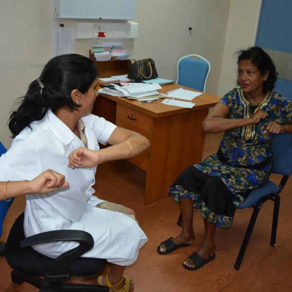 Diabetic Specialist Nurse in Port Louis, Mauritius, teaches a patient simple limb exercises 